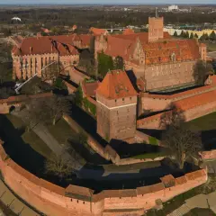 Potężny zamek w Malborku, z czerwonej cegły, otoczony murami obronnymi i fosą. Wspaniałe widoki, które potwierdzają pozytywne opinie o tym miejscu.