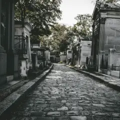Kamienna ścieżka prowadzi przez cmentarz, otoczony mauzoleami. Zastanawiasz się, jak często chodzić na cmentarz?