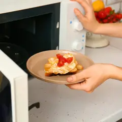 Piatto con toast, uova e pomodorini appena sfornati dal microonde.
