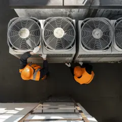 Dos técnicos revisan unidades de aerotermia que es un sistema eficiente de climatización.