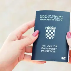 Dwie dłonie trzymają paszport Republiki Chorwackiej. Czy to dowód czy paszport? To paszport, gotowy do podróży.