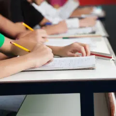 Schüler schreiben in ihren Heften. Ein Bleistift liegt bereit, um die Fortschritte im formative assessment festzuhalten.