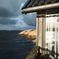 Vacker utsikt från strandvillan i Lysekil över ett stormigt hav och klippor.