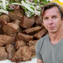 Mężczyzna obok talerza z wątróbką w sosie z cebulą i cytryną. Wątróbka w mleku jest miękka i delikatna.