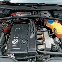 Silnik 1.8t Volkswagena z widocznym logo i oznaczeniem 20V TURBO. Widać elementy układu chłodzenia i dolot powietrza.