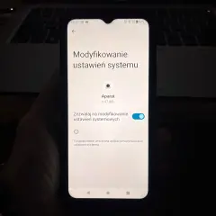 Ekran telefonu pokazuje ustawienia systemu, gdzie można sprawdzić, jak włączyć kamerę w telefonie.