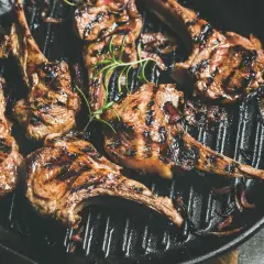 Saftiges Lamm grillen in einer Pfanne mit Rosmarin und Zwiebeln. Perfekt gegrillte Lammkoteletts mit köstlichen Röstaromen.