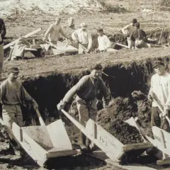 Arbeiter im Gulag Deutsch schaufeln Erde in Schubkarren. Harte Arbeit unter freiem Himmel.