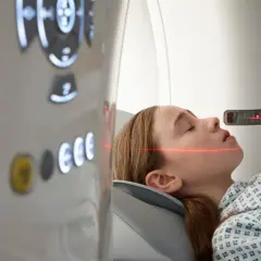 Mädchen in CT-Scanner, rote Laserlinien zur Positionierung für die Untersuchung, um einen ct tumor erkennen zu können.