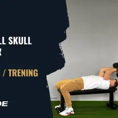 Mężczyzna wykonuje ćwiczenie skull crushers z hantlami leżąc na ławce.