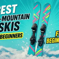 Najlepsze narty all mountain ranking dla początkujących. Kolorowe narty z wiązaniami na tle nieba i śniegu.