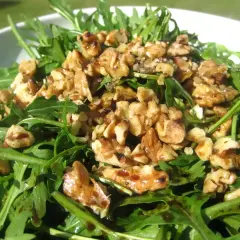 Ensalada de rucula fresca con nueces tostadas y un glaseado balsámico. Un plato ligero y sabroso.