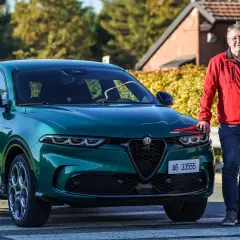 Ein Mann steht neben einem grünen Alfa Romeo Tonale, einem Alfa Romeo Plug-in Hybrid.