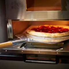 Pizza z pepperoni wjeżdża do pieca z termoobiegiem. Idealna do chrupiącego ciasta!