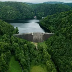 Majestatyczna zapora wodna otoczona bujną zielenią, tworząca jedno z malowniczych jezior na Dolnym Śląsku.
