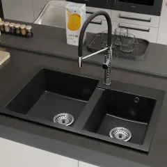 Nowoczesny zlew dwukomorowy z szafką, z czarnym, granitowym wykończeniem i chromowaną baterią. Idealny do każdej kuchni.