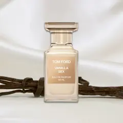 Flakon perfum Tom Ford Vanilla Sex na tle jedwabiu, obok lasek wanilii.
