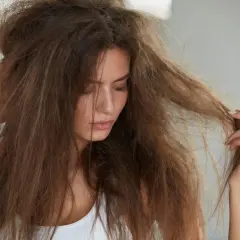 Mujer con pelo seco y sin brillo, enredado y sin vida.