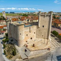 Castillo medieval en un pueblo bonito de Guadalajara, con tejados rojos y cielo azul.