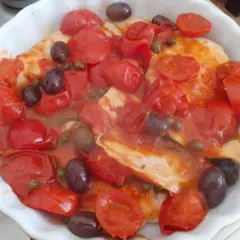 Petto di pollo alla pizzaiola in teglia, con pomodorini, olive nere e capperi. Un piatto saporito e colorato.
