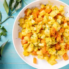 Insalata di sedano rapa e carote a cubetti, condita con erbe aromatiche. Un'idea fresca per le tue ricette crudiste.