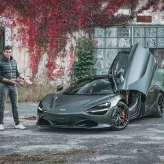 Mężczyzna prezentuje szarego McLarena 720S z otwartymi drzwiami. Zastanawiasz się nad mclaren 720s cena?