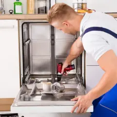 Instrukcja: jak zamontować front do zmywarki Bosch. Fachowiec używa wiertarki do mocowania.