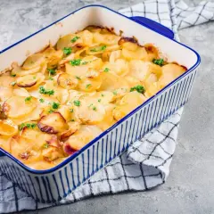 Goldbrauner Kartoffelauflauf mit Petersilie in einer blauen Auflaufform. Ein köstliches Kartoffelauflauf Rezept, das zum Genießen einlädt.