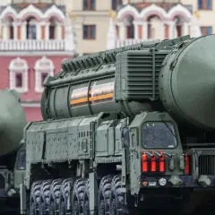 Ciężarówki z rakietami, potężna broń balistyczna, przemierzają ulice. Na tle historycznych budynków widać potęgę militarną.