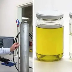 Man visar upp en tank för blankdiesel i personbil. Bredvid står två burkar med vätska, en gul och en klar.