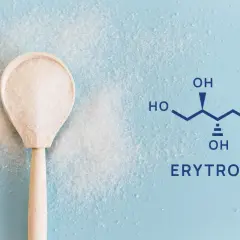 Drewniana łyżka z kryształkami erytrolu obok wzoru chemicznego. Erytrytol to zdrowa alternatywa dla cukru.