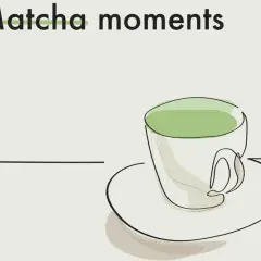 Kubek z zieloną matchą, która ma kofeinę, na talerzyku. Napis "Matcha moments".