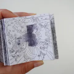 Un libro desplegable con dibujos de manualidades del Mago de Oz, mostrando al León, el Espantapájaros y Dorothy.