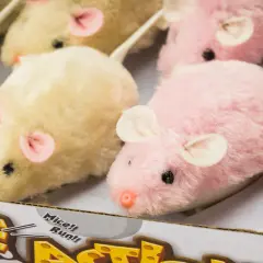Kilka pluszowych, nakręcanych myszek w pastelowych kolorach, gotowych do biegu.