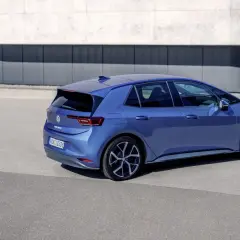 Niebieski Volkswagen ID.3 Neo stoi na tle nowoczesnego budynku.