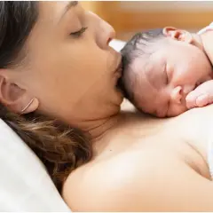 Mamma bacia il suo neonato, un momento di tenerezza che celebra la fine delle 38 settimane di gravidanza, quanti mesi sono circa nove.