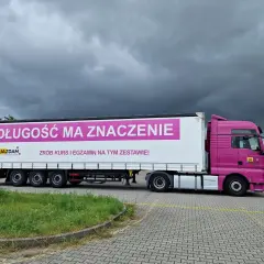 Różowy ciągnik z naczepą, na której widnieje napis "DŁUGOŚĆ MA ZNACZENIE". Idealny do nauki manewrów z dopuszczalną masą całkowitą zespołu pojazdów c+e.