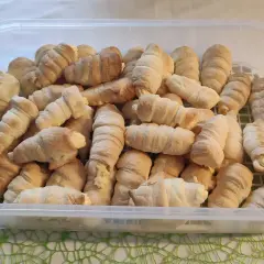 Duża porcja rurek z kremem w przezroczystym pojemniku.