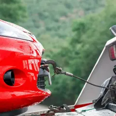 Czerwony samochód holowany na lawetę. Brak ważnego przeglądu może skutkować mandatem i odholowaniem pojazdu.