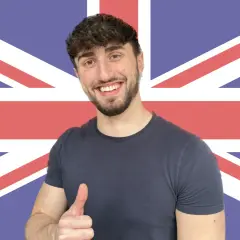 Giovane sorridente con pollice in su, sullo sfondo della Union Jack. Ha deciso di get phrasal verb per imparare l'inglese.