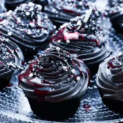 Mroczne muffinki halloween z czarną polewą, czerwonym lukrem i kolorową posypką.