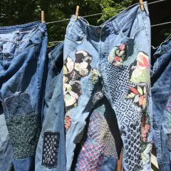 Jeans repaired with colorful patches and intricate stitching, showcasing creative ways how to darn.