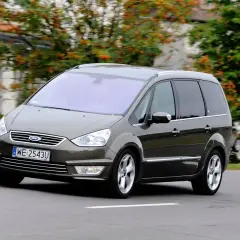 Brązowy Ford Galaxy MK2 w ruchu, z widocznymi felgami i tablicą rejestracyjną WE 2543U.