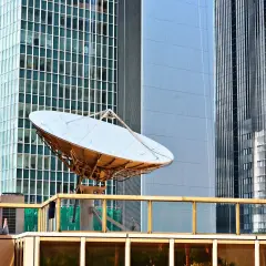 Antena satelitarna na dachu budynku, gotowa do ustawienia jak talerz Cyfrowego Polsatu.