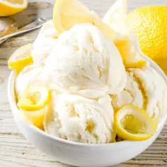 Coppa di cremoso gelato al limone bimby, guarnita con spicchi freschi. Un'esplosione di freschezza estiva.