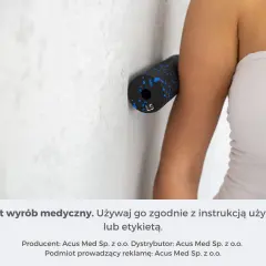 Roller do masażu ramienia przy ścianie, pomocny w domowym leczeniu bólu łokcia.