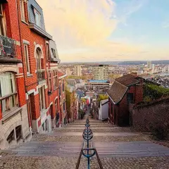 Treppen hinunter in eine Stadt in Belgien. Erkunden Sie die charmanten Gassen und genießen Sie die Aussicht – so kann man in Belgien machen!