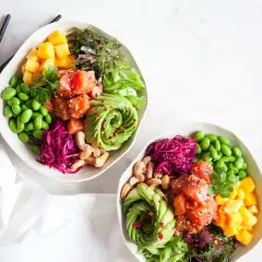 Två färgglada bowls med lax, avokado, mango, edamame och rödkål. Perfekt för en hälsosam lunch eller middag, inspirerade av bowls recept.