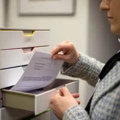 Kobieta przegląda dokumenty, szukając informacji, jak napisać apelację do sądu.