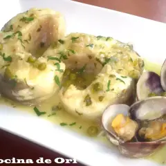 Congrio en salsa verde con guisantes y almejas, un plato delicioso y lleno de sabor.